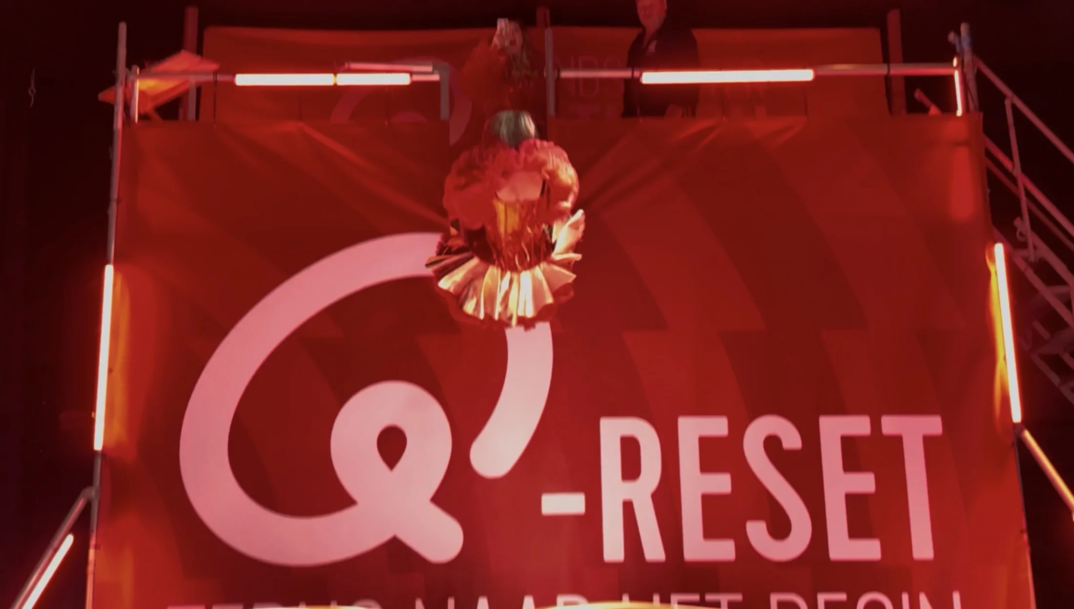 Actiemoment voor de grote, bedrukte Q-RESET-merkachterwand