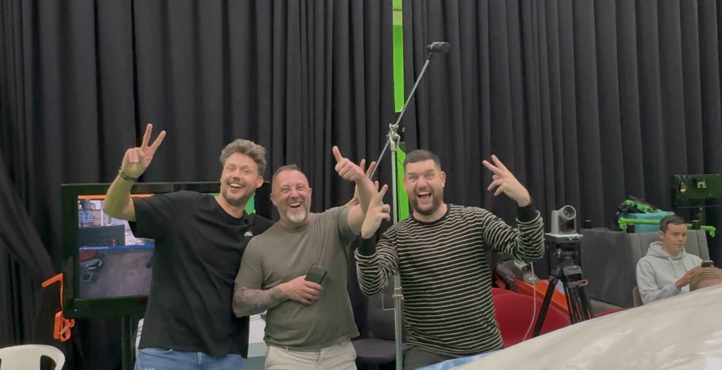 Drie deelnemers lachen uitbundig naar de camera